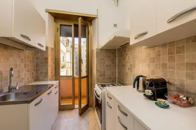 a kitchen with white counters and a sink and a stove at Italia Room vicino Stazione Termini in Rome