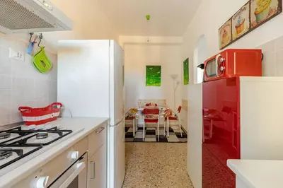 a kitchen with a stove and a red refrigerator at Aura Home Grazioso Appartamento a Pochi Passi dalla Metro A e C in Rome