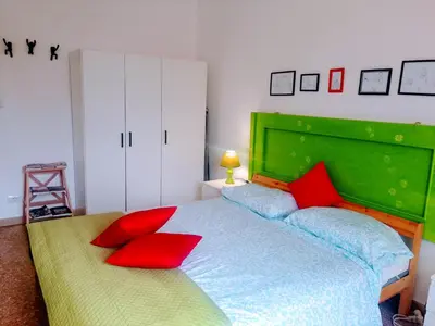 a bedroom with a green bed with red pillows at Aura Home Grazioso Appartamento a Pochi Passi dalla Metro A e C in Rome