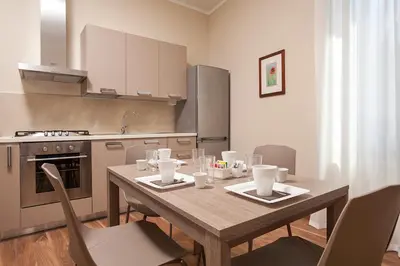 a kitchen with a wooden table with chairs and appliances at Window On Rome in Rome