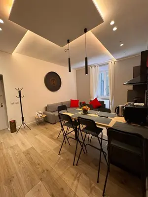 a living room with a table and chairs and a couch at GetRoma apartment Vatican Museum in Rome