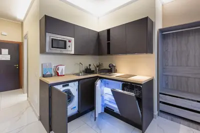 a kitchen with a washing machine and a microwave at Aurelia Boutique Apartment in Rome