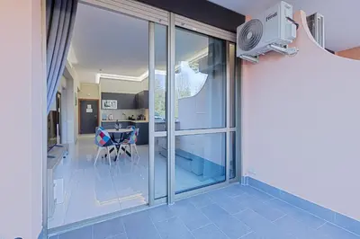 a room with glass doors and a kitchen with a table at Aurelia Boutique Apartment in Rome