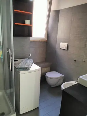 a bathroom with a toilet and a sink and a window at Appartamento Monteverde in Rome