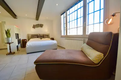 a bedroom with a bed and a couch and a chair at Poetico Monolocale Indipendente nell’Antico Pastificio in Rome