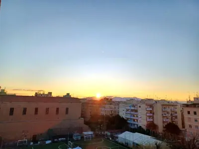 a sunset over a city with tall buildings at Pigneto Happy Stay in Rome