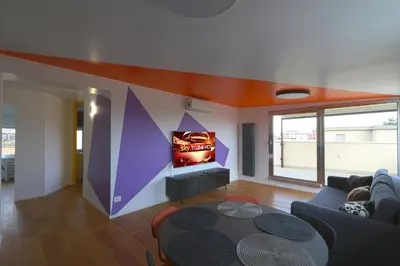 a living room with a video game on the wall at Angela attico a pochi minuti dal Gemelli e Stazione FL3 direzione San Pietro - Roma centro in Rome