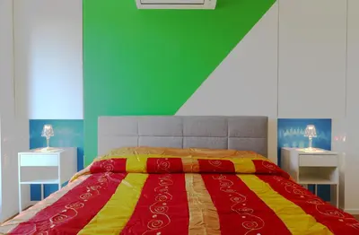 a bedroom with a colorful bed with two night stands at Angela attico a pochi minuti dal Gemelli e Stazione FL3 direzione San Pietro - Roma centro in Rome