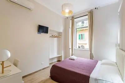 a white bedroom with a bed and a window at Mirabilia House in Rome