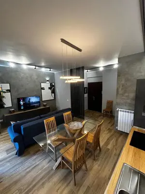 a living room with a blue couch and a table and chairs at SPQR Luxury Appartments - Stazione Trastevere in Rome