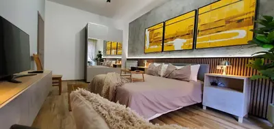 a bedroom with a bed and a yellow painting on the wall at SPQR Luxury Appartments - Stazione Trastevere in Rome