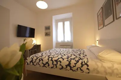 a bedroom with a bed and a tv on the wall at Risorgimento Holiday Home in Rome