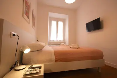 a bedroom with a bed and a television on the wall at Risorgimento Holiday Home in Rome