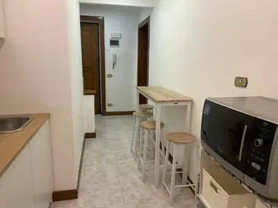 a kitchen with a counter and a microwave and stools at Blue Vatican House in Rome