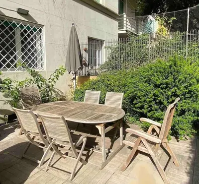 a wooden table with chairs and an umbrella on a patio at Vacanze Romane in Rome