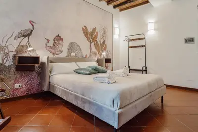a bedroom with a bed with a wall with birds on it at La Maisonette di Trastevere in Rome