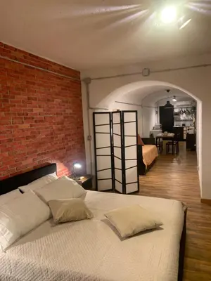 a bedroom with a white bed and a brick wall at DOMUS LAURA Rione MONTI in Rome