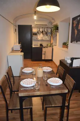 a dining room table with four chairs and a kitchen at DOMUS LAURA Rione MONTI in Rome