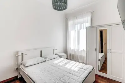 a white bedroom with a bed and a window at Re di Roma Lovely Apartments in Rome