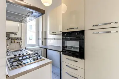 a kitchen with white cabinets and a stove top oven at Re di Roma Lovely Apartments in Rome