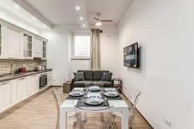 a kitchen and living room with a table and a couch at New flat in front StPeter Square in Rome