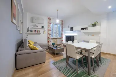 a dining room and living room with a table and a couch at [CASA LUCIA 5 stelle] Lungotevere della Vittoria in Rome