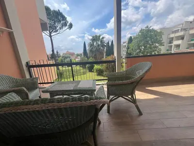 a patio with a table and chairs and a view of a courtyard at GREEN HOUSE - PARCO TIRRENO by Ohana in Rome