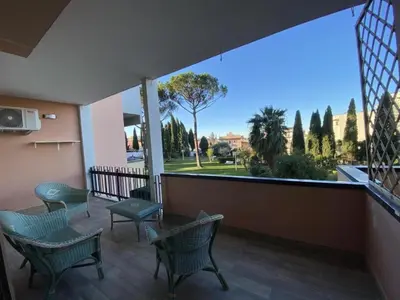 a balcony with chairs and a view of a park at GREEN HOUSE - PARCO TIRRENO by Ohana in Rome