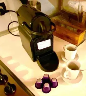 a coffee maker sitting on a counter with a cup of coffee at Vacanze Romane al Portico d'Ottavia in Rome