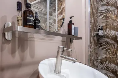 a bathroom with a sink and some bottles on a shelf at The Space Rooms in Rome