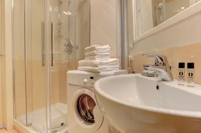 a bathroom with a sink and a washing machine at Home and More St. Angelo APT 5 in Rome