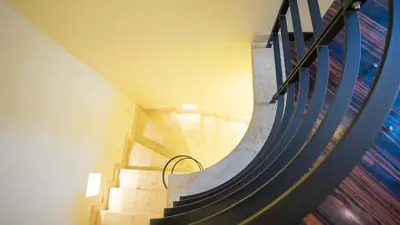 a spiral staircase in a building with a blue railing at EasyTopStay - Piazza Venezia City View Charming Apt in Rome