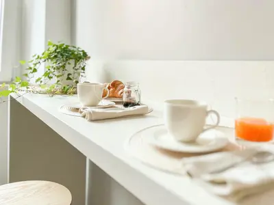 a white counter with two cups and plates of food at Grazioso appartamento al Pigneto in Rome