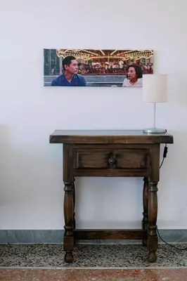 a table with a lamp and a picture on the wall at Villa Fiorelli rooms in Rome