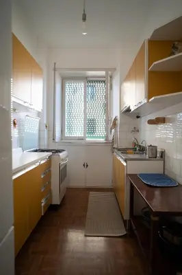a kitchen with yellow cabinets and a sink and a window at Villa Fiorelli rooms in Rome