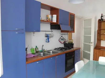 a kitchen with blue cabinets and a sink at Appartamento 5 stelle in Piazza Asti - Re di Roma - in Rome