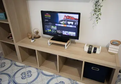 a flat screen tv sitting on top of a wooden entertainment center at Stanza da Apollo e Diana in Rome