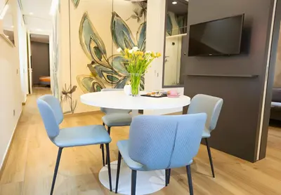 a dining room with a white table and blue chairs at The Best Nest - Home Suite Home NEW OPENING in Rome