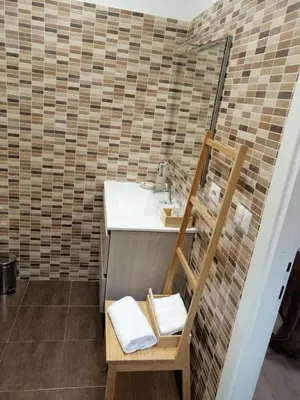 a bathroom with a sink and a wooden chair at San Pietro Happy Home in Rome