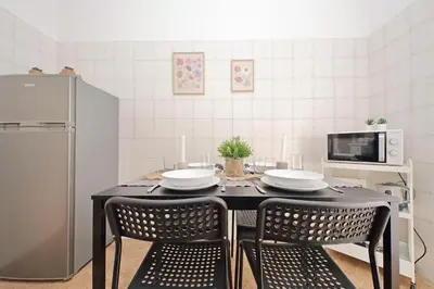 a kitchen with a table with two chairs and a microwave at A Casa di Domenico in Rome
