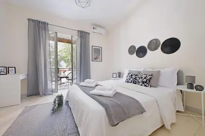a white bedroom with a large bed and a balcony at A Casa di Domenico in Rome