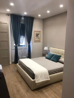 a bedroom with a large bed with blue pillows at Pinciano 1stfloor in Rome