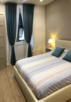 a bedroom with a large bed with blue curtains at Pinciano 1stfloor in Rome