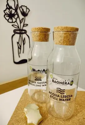 two bottles of water sitting on a counter with a flower at Bagnera51 in Rome