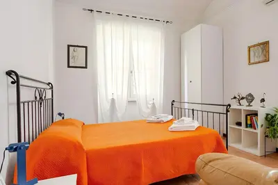 a bedroom with a bed with an orange blanket at Rome artist house in Rome
