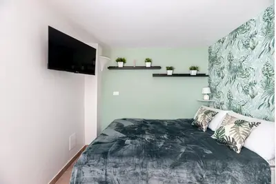 a bedroom with a bed and a flat screen tv at Lungaretta Studio Flat [trastevere] in Rome