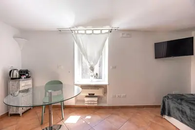 a living room with a glass table and a window at Lungaretta Studio Flat [trastevere] in Rome