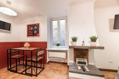 a living room with a fireplace and a table and chairs at Lungaretta Studio Flat II (Trastevere) in Rome