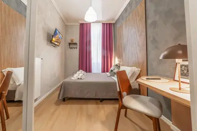 a small room with a bed and a table and chair at Maison Macao - Golden Keys Collection in Rome