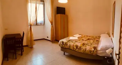 a bedroom with a bed and a desk and a window at San Giovanni Apartment in Rome